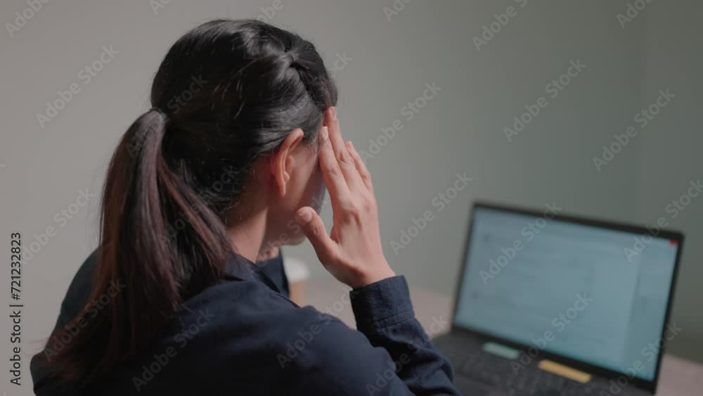 Woman reads bad news on laptop computer while sitting at work and is disappointed with notifications she receives news Woman reads bad news on laptop computer while sitting at work and is disappointed with notifications she receives news