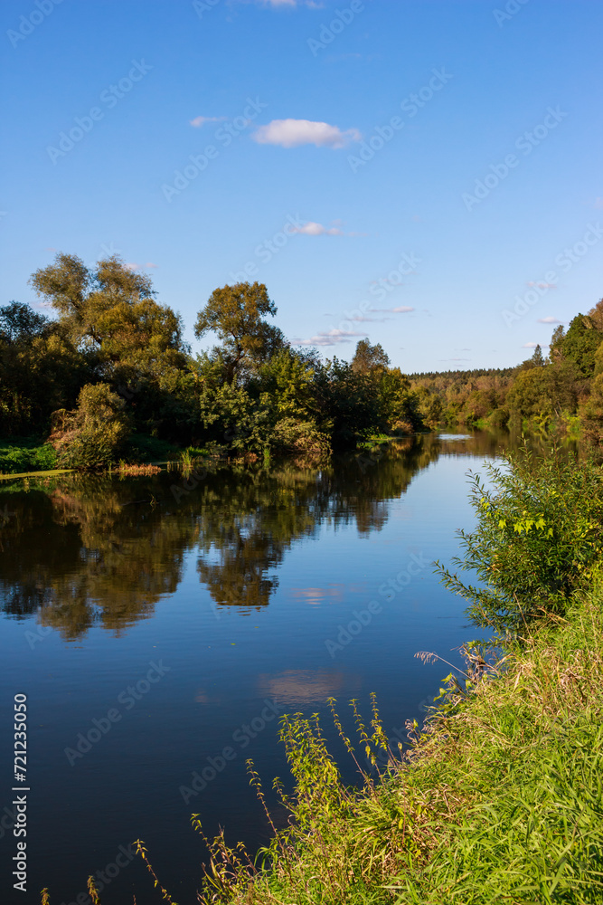 A picturesque landscape overlooking a serene river surrounded by green banks covered with trees A picturesque landscape overlooking a serene river surrounded by green banks covered with trees