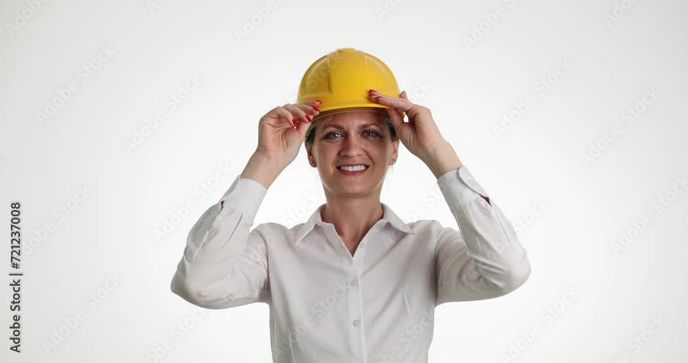 Beautiful female builder puts on yellow helmet. Construction repair and reconstruction of house or apartment Beautiful female builder puts on yellow helmet. Construction repair and reconstruction of house or apartment