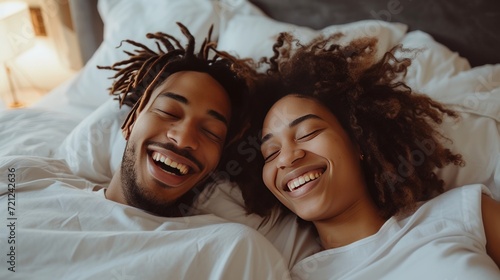 Young couple lying in bed and laughing