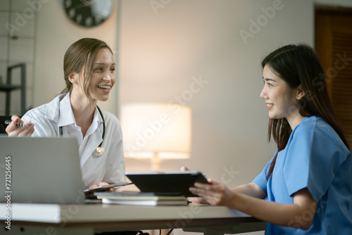 Female doctor sitting at work looking at the history of patients in the clinic or in the hospital