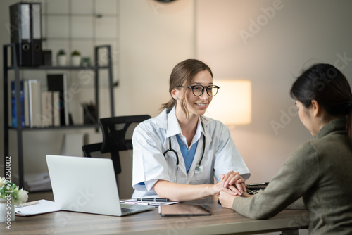 Female doctor sitting at work looking at the history of patients in the clinic or in the hospital