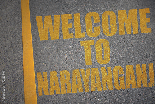 asphalt road with text welcome to Narayanganj near yellow line. photo