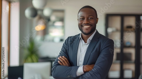 Portrait of smiling african businessman standing in office with crossing hands