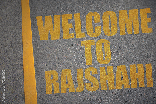asphalt road with text welcome to Rajshahi near yellow line. photo