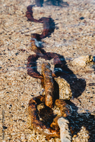 Obraz na płótnie Chaîne d'amarrage rouillé immerger dans l'eau au bord de la plage de Saint Victor sur Loire w salonie
