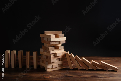 Falling wooden block game stick from falling domino concepts of financial risk management and strategic planning