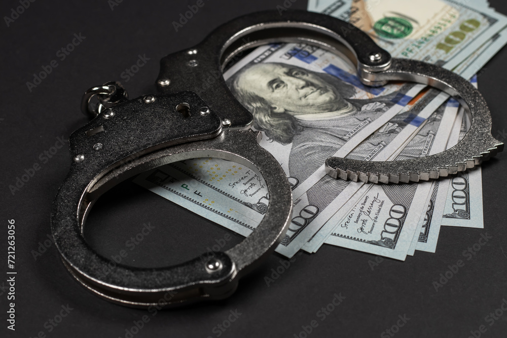 American dollars and handcuffs, Concept of ideas of corruption, dirty money or financial crimes American dollars and handcuffs, Concept of ideas of corruption, dirty money or financial crimes