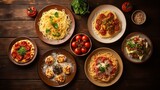 Top view of a festive table with delicious Italian dishes on plates on a brown wooden background.