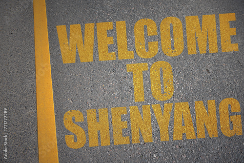 Photos asphalt road with text welcome to Shenyang near yellow line.