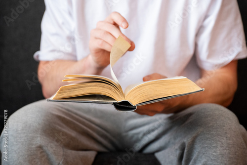 man sitting on couch and reading book