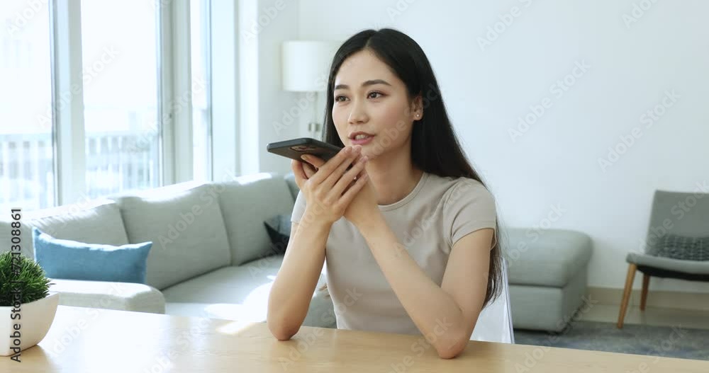 Serious young Asian smartphone user woman recording voice audio message on smartphone, talking on cellphone speaker, speaking at mobile phone, finishing conversation, using gadget for communication Serious young Asian smartphone user woman recording voice audio message on smartphone, talking on cellphone speaker, speaking at mobile phone, finishing conversation, using gadget for communication