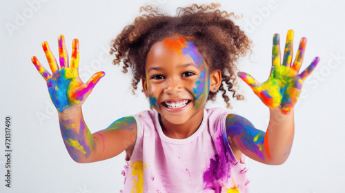 Portrait of a cute little girl showing her hands painted in bright colors