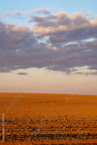 The image shows a rocky terrain with a distant horizon and clouds above.
