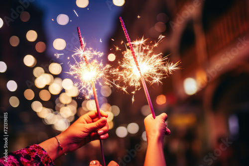 Woman hands holding sparkler on bokeh background. New year concept