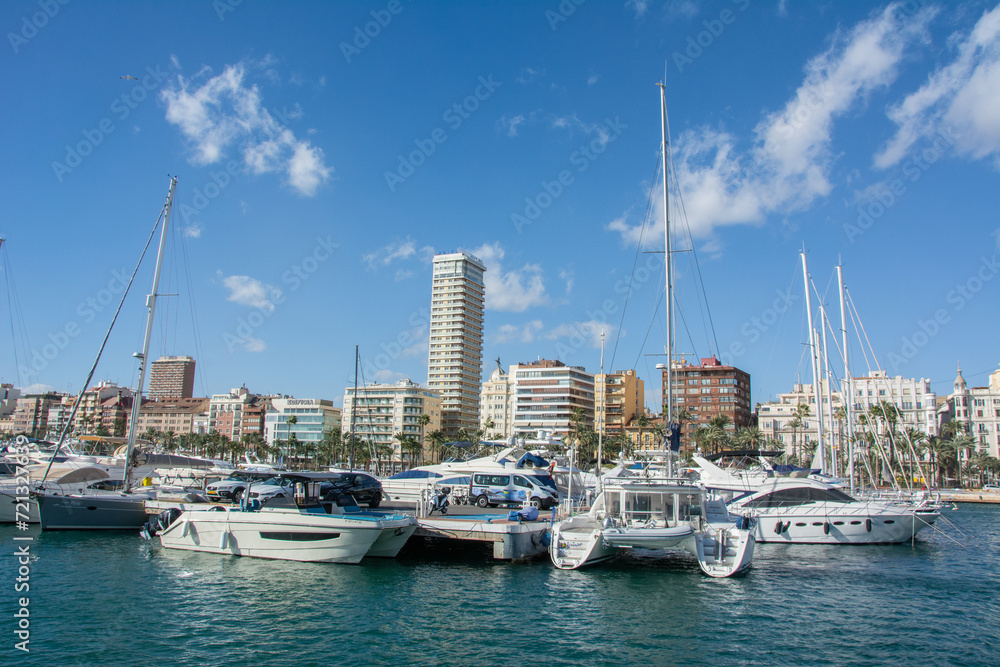 View of Alicante harbor with yachts and boats, blue sky and beautiful clouds seen from the Mediterranean Sea in Spain