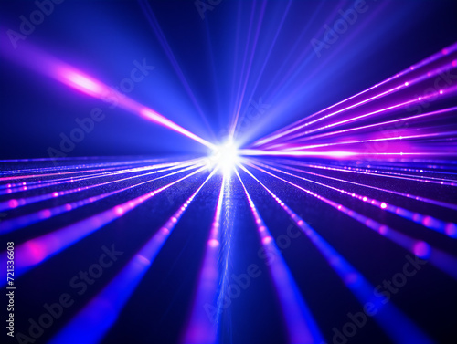 Blue and violet beams of bright laser light with black background.