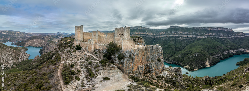 Obraz premium Aerial panoramic view of Chirel castle atop a rocky crag jutting out over el Jugar gorge in Cortes de Pallas, with triangular layout, arrow slits, parapets, moa, water tank, main tower