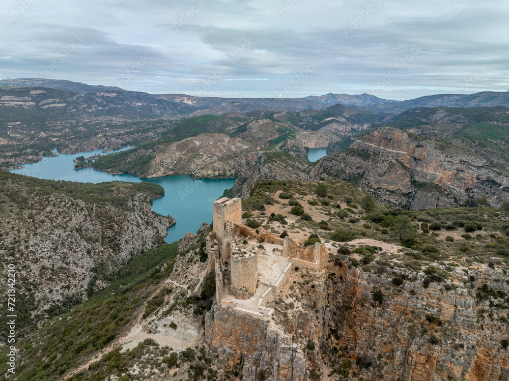 Aerial panoramic view of Chirel castle atop a rocky crag jutting out over el Jugar gorge in Cortes de Pallas, with triangular layout, arrow slits, parapets, moa, water tank, main tower