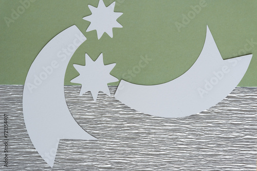 two stylized paper stars on green and silver crepe paper background