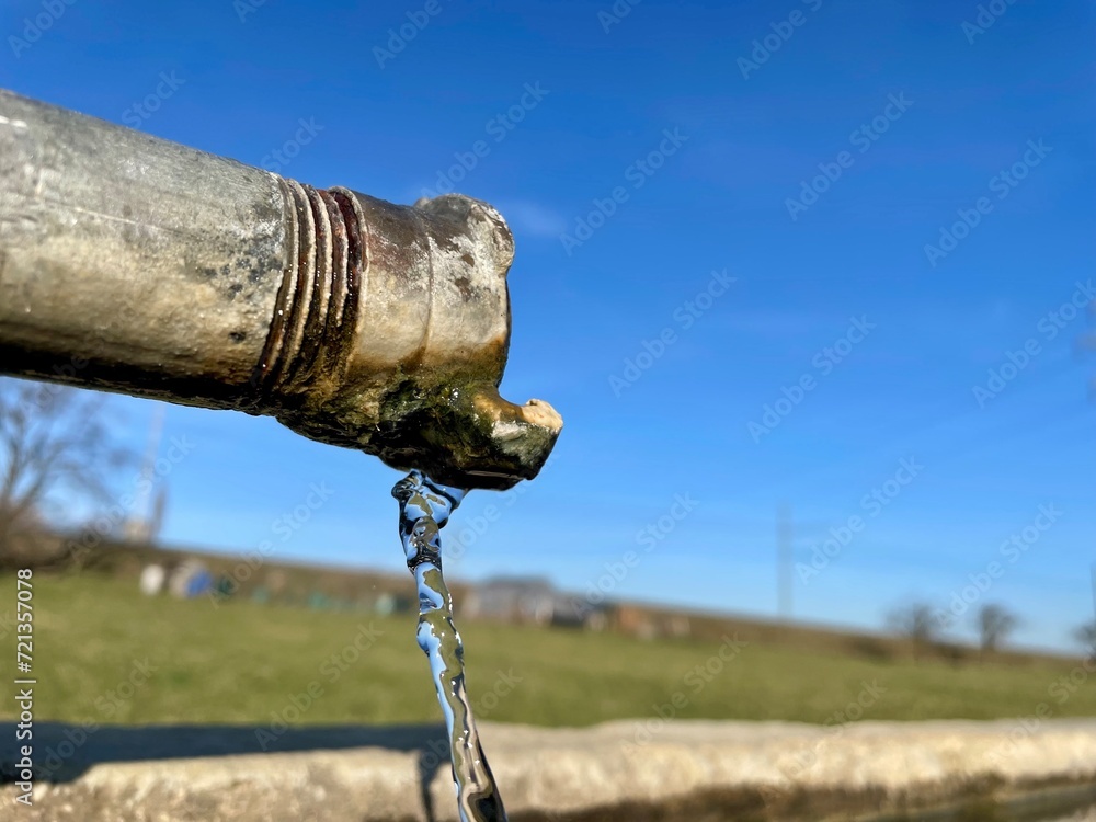 Fototapeta premium Fliessendes Wasser aus dem Brunnen