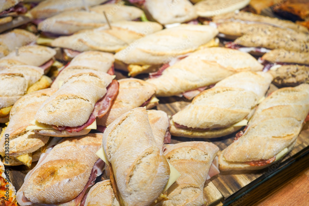 Ham and cheese sandwiches on crusty baguettes arranged on a platter. Ham and cheese sandwiches on crusty baguettes arranged on a platter.