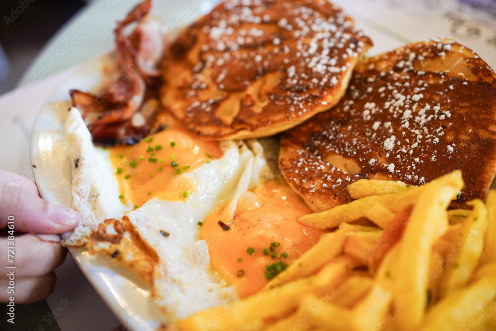 A close-up of a classic American breakfast with pancakes and eggs. A close-up of a classic American breakfast with pancakes and eggs.