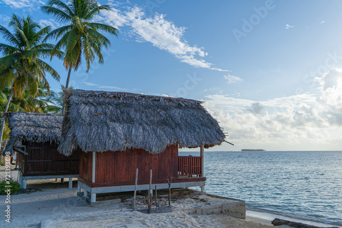 Red painted beach hut with palm trees at Panama bech on San Blas islands