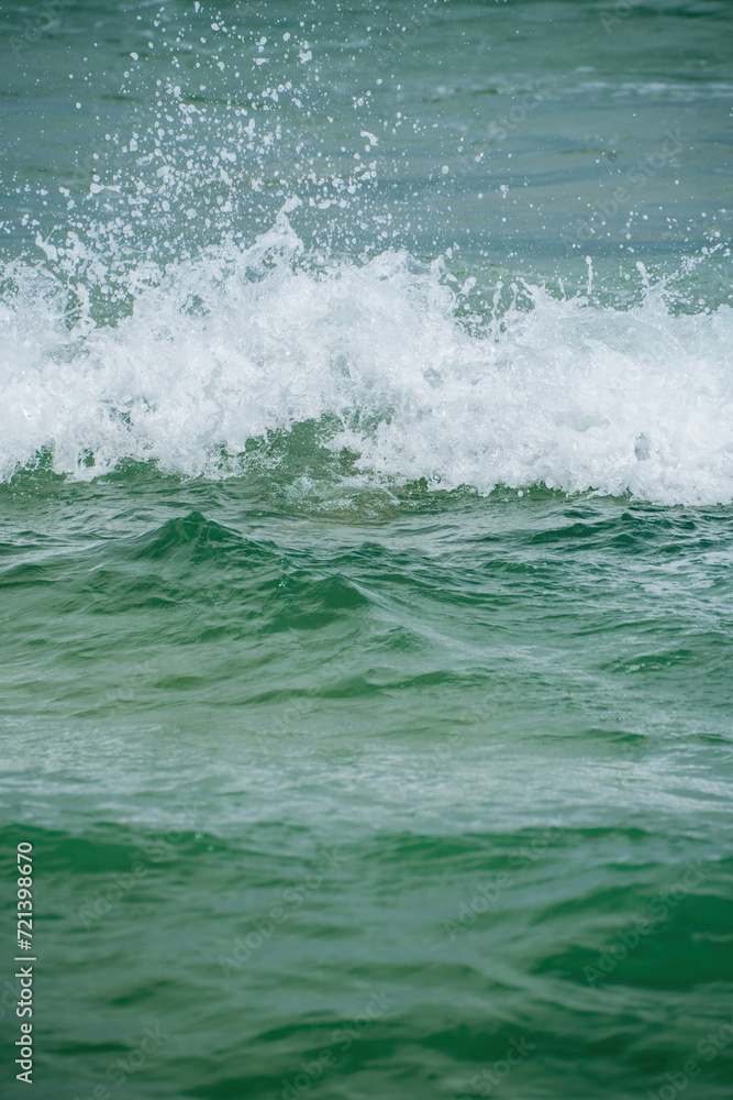 Green-blue water wave splash with white foam in Bastimentos Panama vertical format Green-blue water wave splash with white foam in Bastimentos Panama vertical format