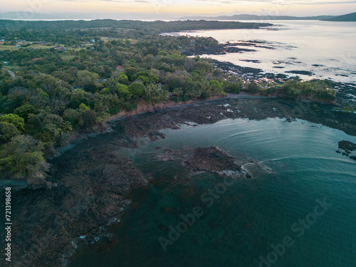 High altitude drone view of rocky beach during low tide in Santa Catalina during sunset