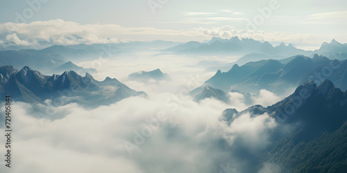 Misty Mountains: Majestic Scenery with Tranquil Valley, Foggy Peaks, and Snow-Covered Rocks against a Blue Sky.