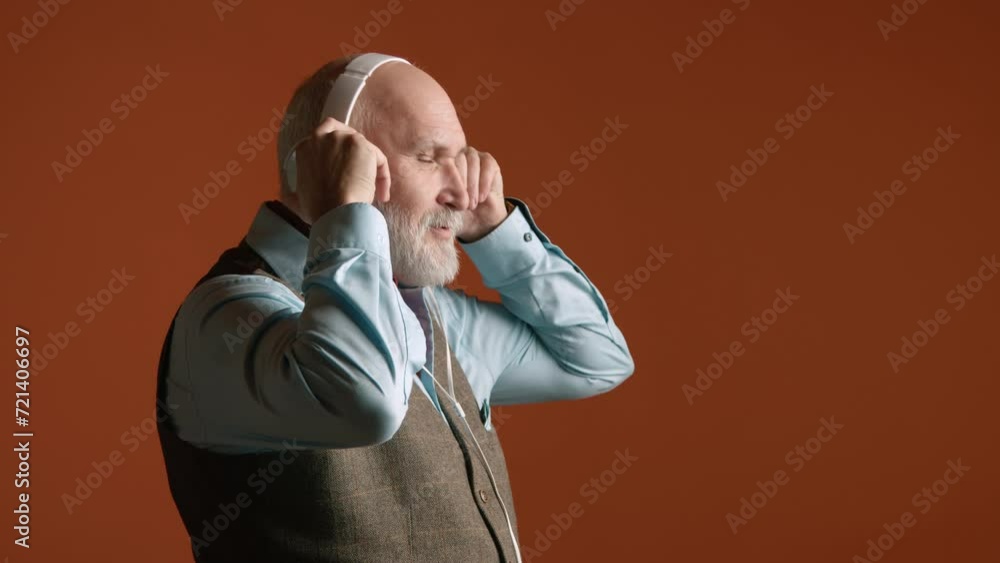 An individual immerses in the peaceful serenity of classical tunes, donning cozy headphones against an orange background, feeling the music's embrace. Camera 8K RAW. An individual immerses in the peaceful serenity of classical tunes, donning cozy headphones against an orange background, feeling the music's embrace. Camera 8K RAW.
