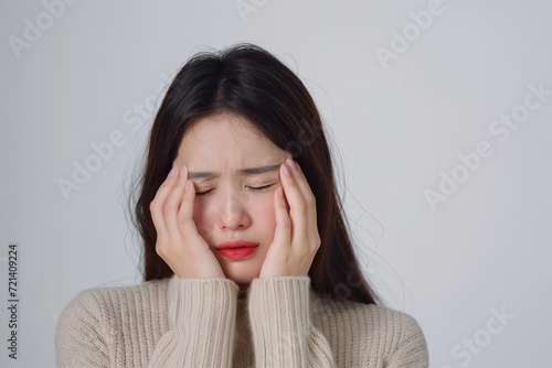 Woman touching her head with hands. Young asian woman feel headache. Isolated on white background