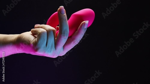 In the hands of a young girl vibro toy for sexual pleasures. The girl is holding a sex shop toy Sex toy clitoral vibrator photo