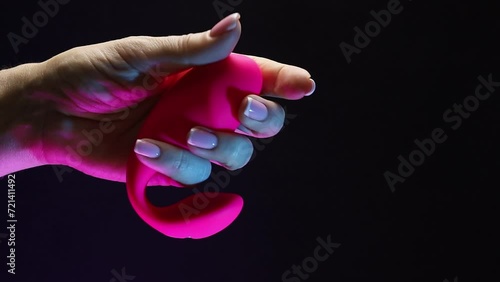 In the hands of a young girl vibro toy for sexual pleasures. The girl is holding a sex shop toy Sex toy clitoral vibrator
