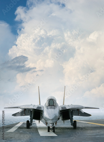 F-14 jet fighter on an aircraft carrier deck beneath dramatic clouds viewed from front
