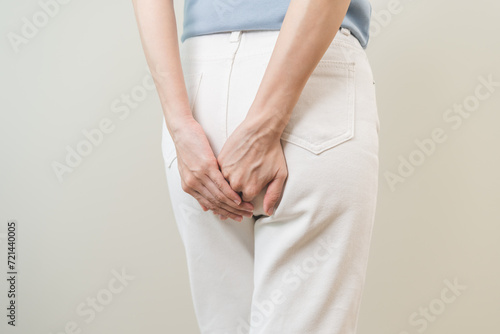 Health care, pain asian young woman suffering from hemorrhoid, anus, diarrhea and constipation, girl hand touching, holds butt, anal have abdominal, intestine problem, abscess disease and smell fart. photo