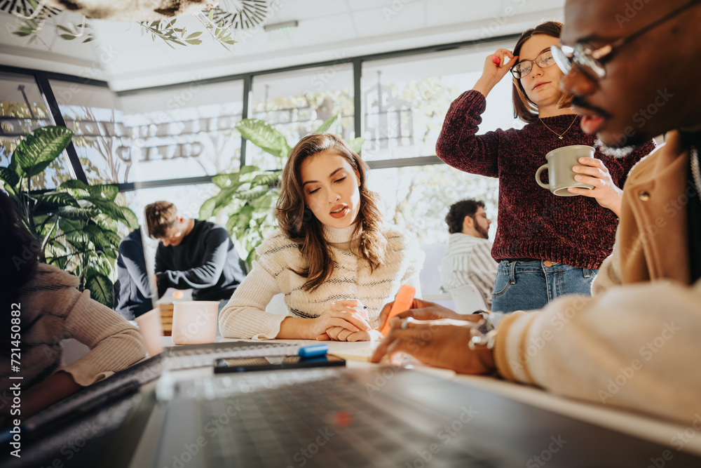 Obraz premium Multiethnic business professionals collaborate in an office, brainstorming ideas and solving problems. They aim for growth and success through teamwork and innovation.
