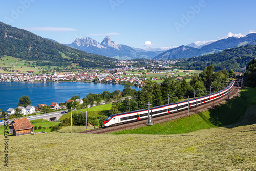 Passenger train type Stadler Giruno of Schweizerische Bundesbahnen SBB at Grosser Mythen mountain at Lake Zug in the Swiss Alps in Arth, Switzerland photo