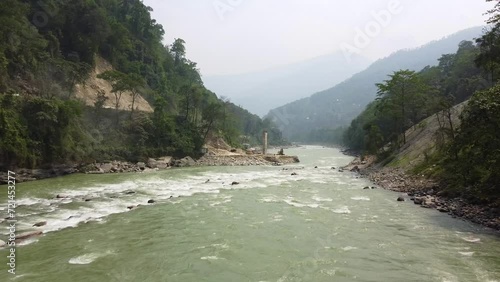 Aerial view above the Tista river, in a valley between mountains and Indian forest, on a sunny day, in Sikkim, India. photo