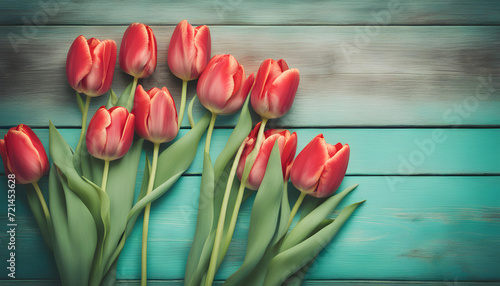 Fresh spring red tulips flowers on turquoise painted wooden planks.