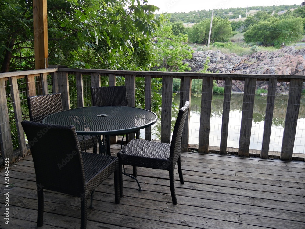 Tables and chairs on the terrace of a wooden house by the river