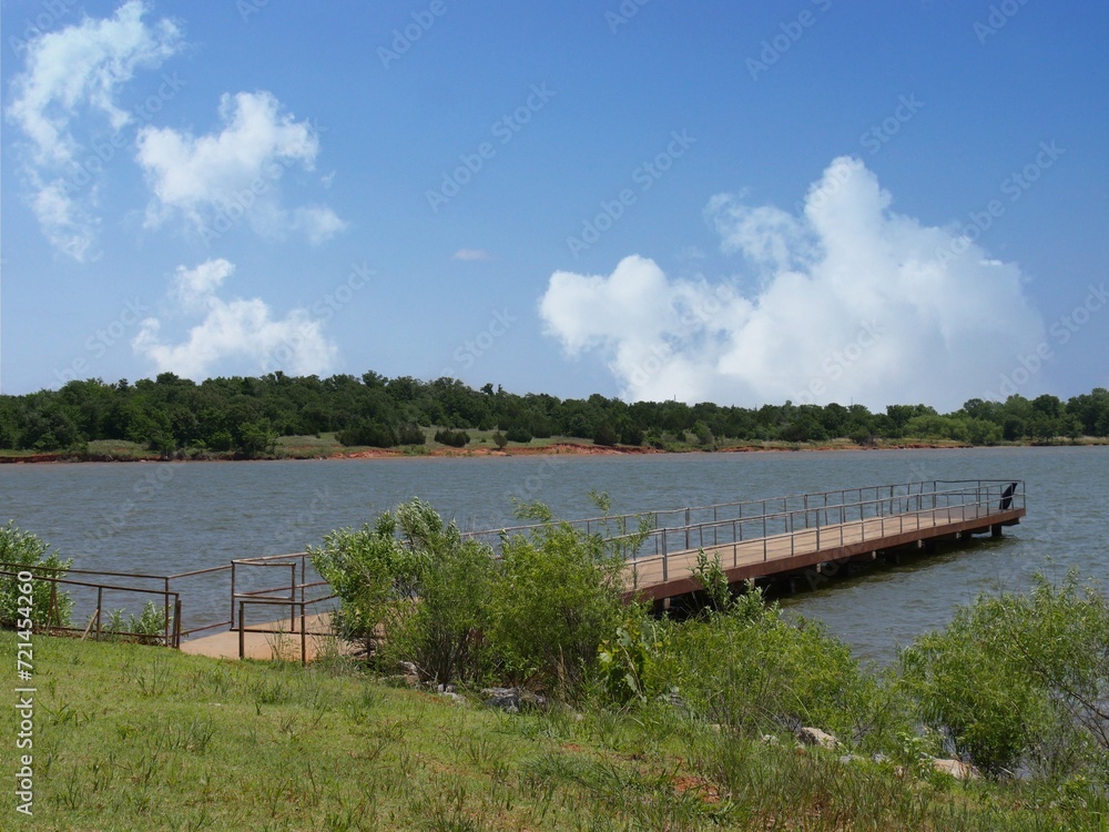 Wooden bridge over the river. Summer landscape with blue sky. Wooden bridge over the river. Summer landscape with blue sky.