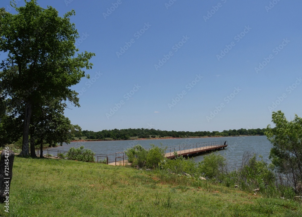 Wide shot of a lakeside with a wooden boat dock