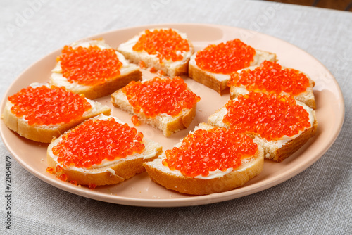 Sandwiches with red caviar on a table on a white tablecloth close-up.