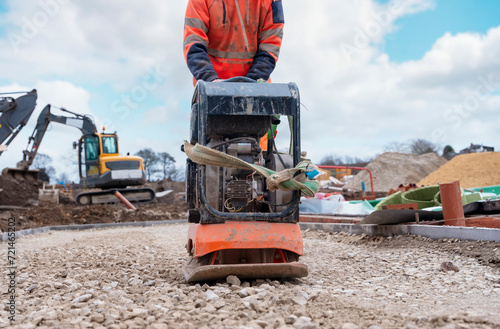 Photos Vibrating plate compactor osed to compact ground and stone on building site