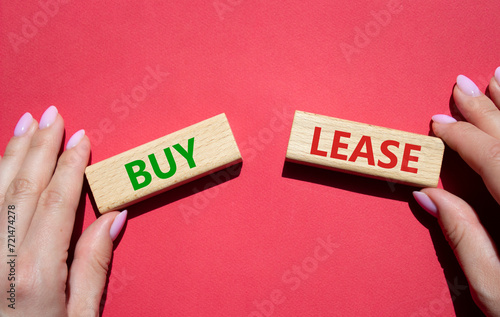 Buy or Lease symbol. Concept word Buy or Lease on wooden blocks. Businessman hand. Beautiful red background. Business and Buy or Lease concept. Copy space