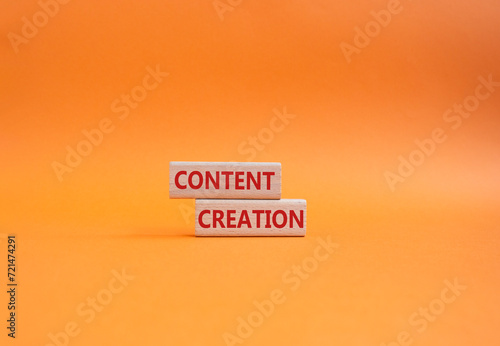 Content creation symbol. Concept word Content creation on wooden blocks. Businessman hand. Beautiful orange background. Business and Content creation concept. Copy space