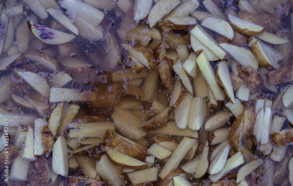 Top View of Potato Cut Pieces Washing in Water for Cooking