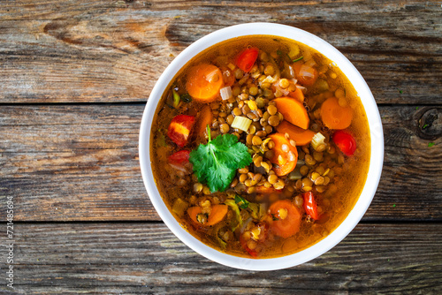 Fresh vegetable soup with lentil on wooden table

 photo